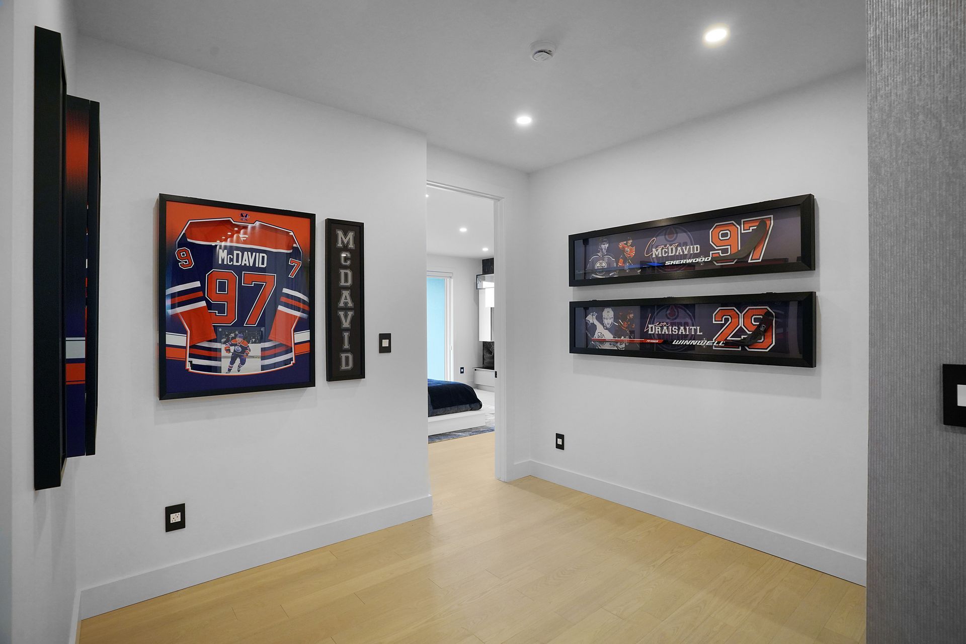 A hallway with a painting of a hockey jersey on the wall.