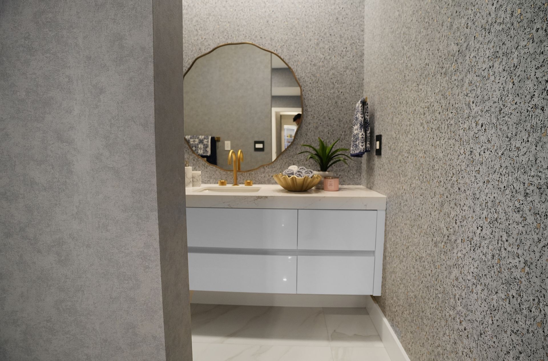 A bathroom with a sink , mirror and towel rack.