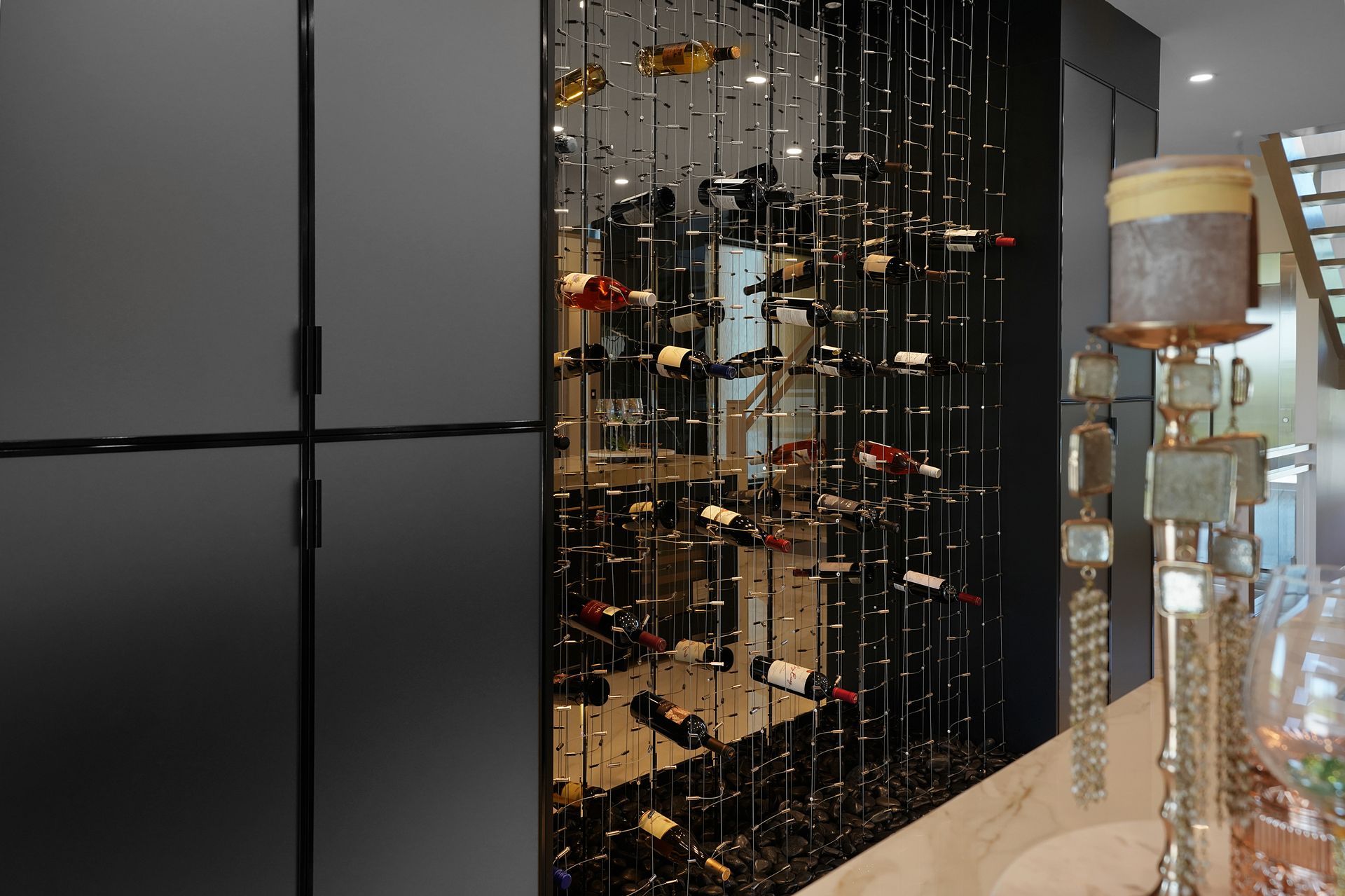 A wine cellar with a lot of wine bottles hanging from the ceiling.