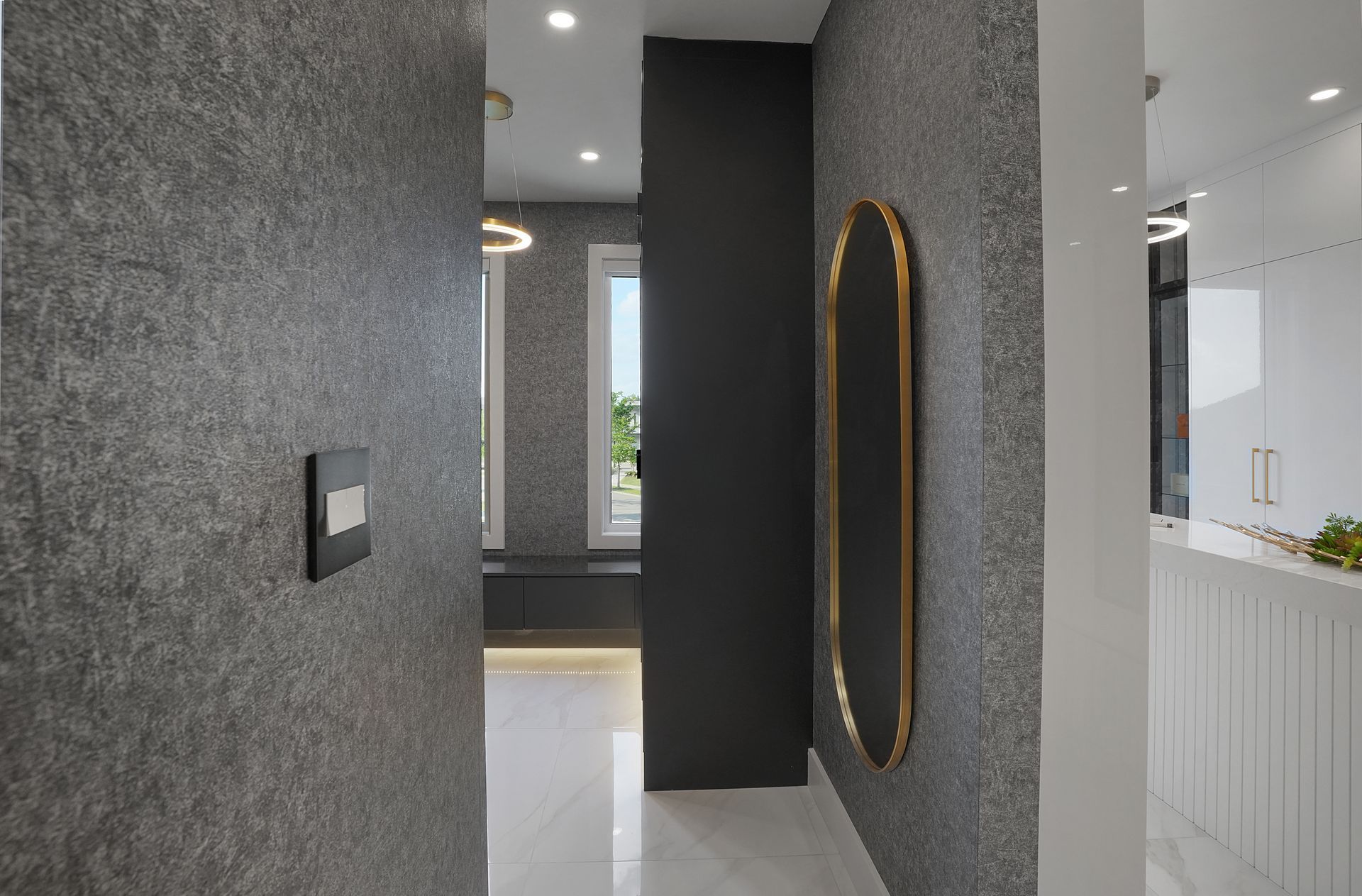 A hallway in a house with a mirror on the wall.