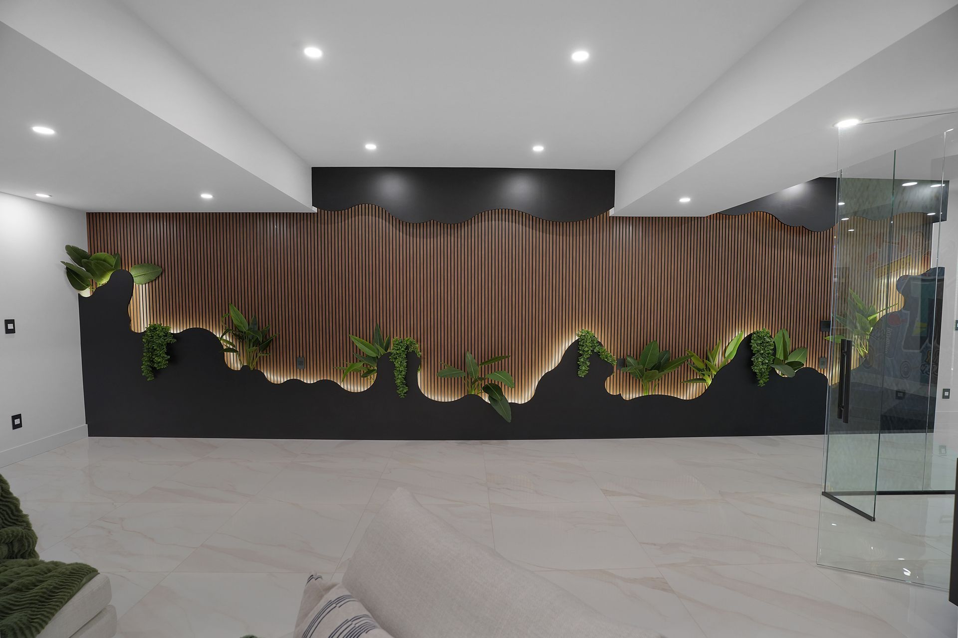 A living room with a wooden wall and plants on it.