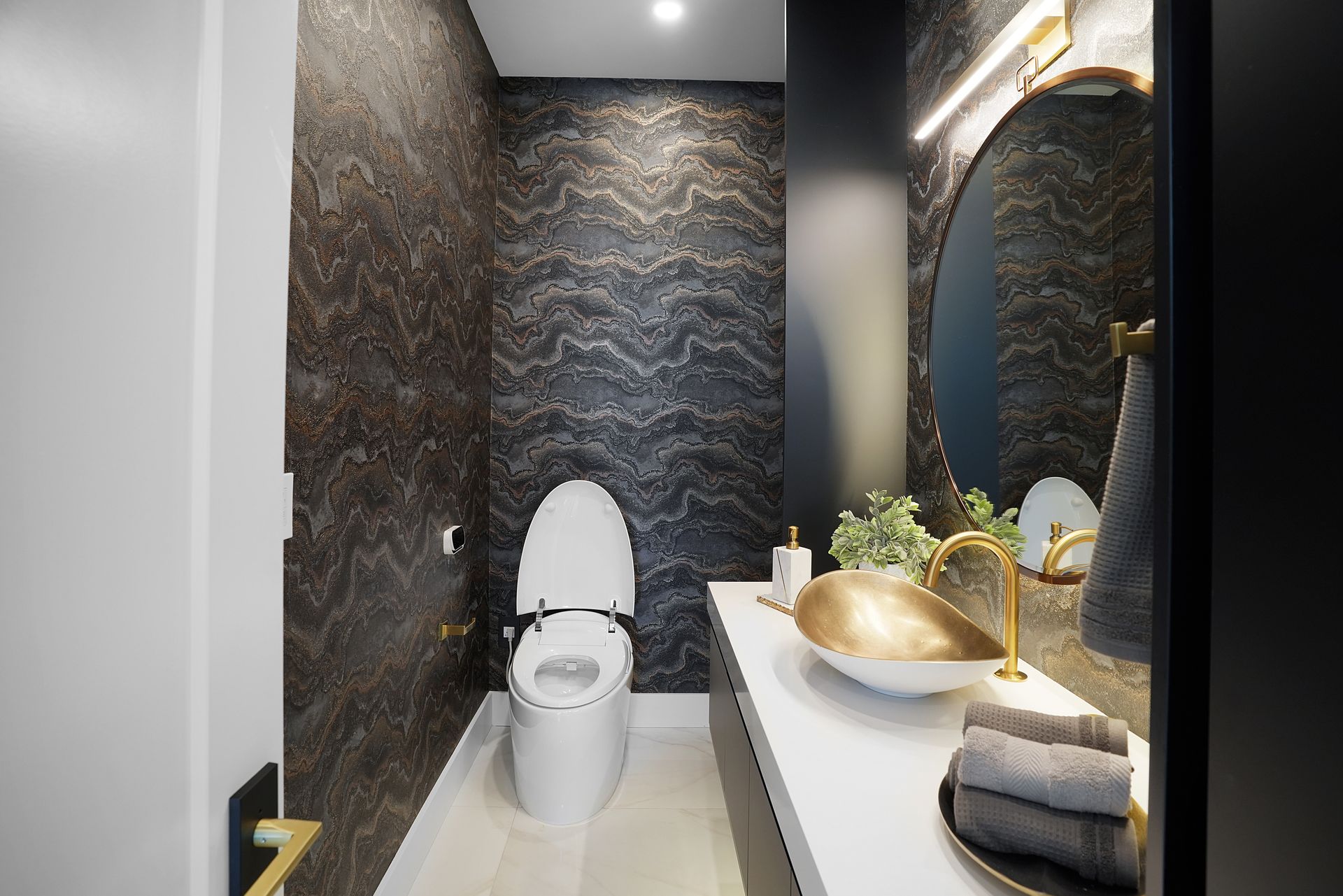 A bathroom with a toilet , sink and mirror.