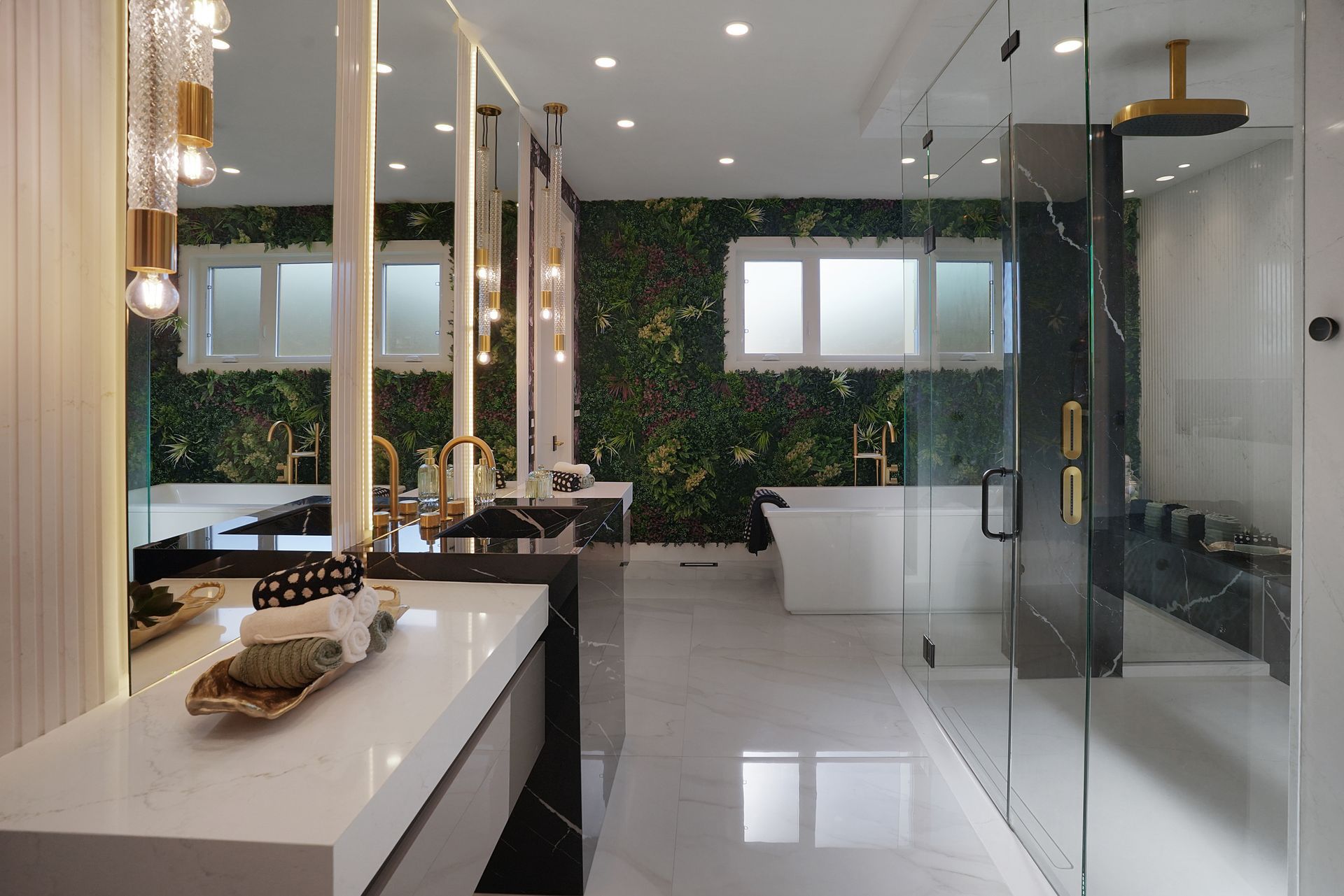 A bathroom with two sinks , a tub , and a walk in shower.