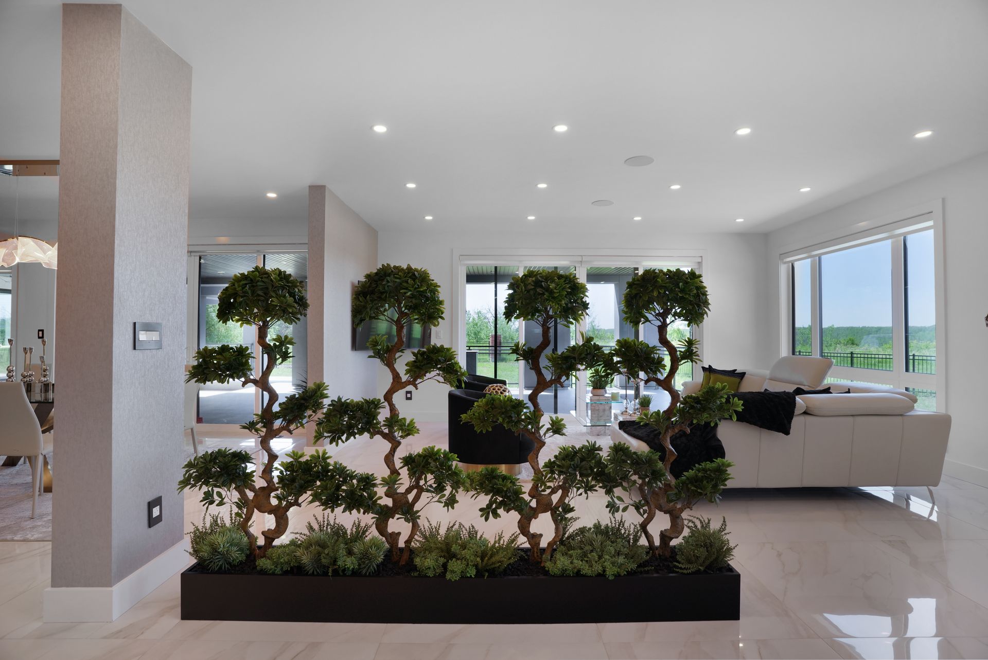 A living room with a couch and a divider made of trees