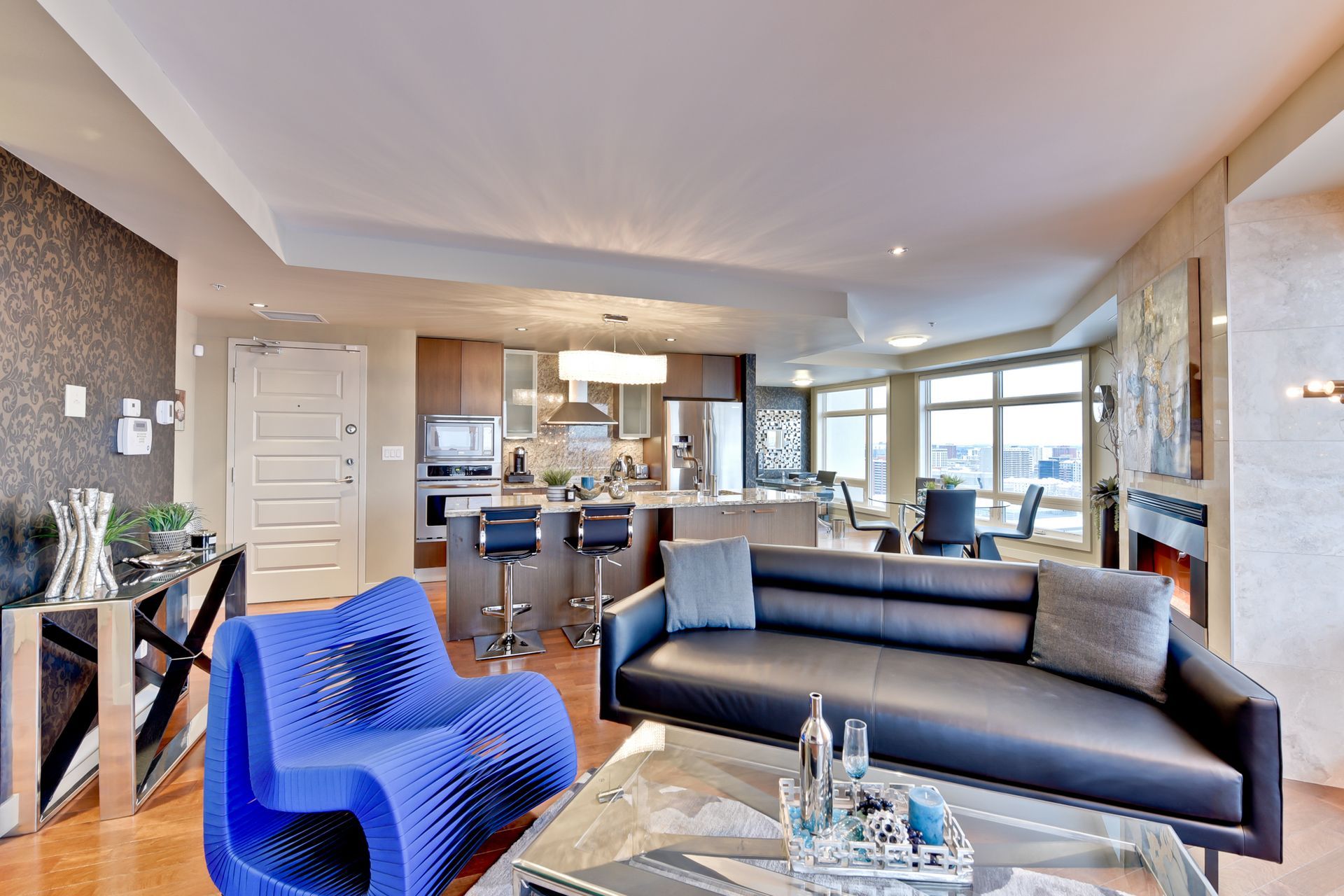 A living room with a black couch and blue chairs