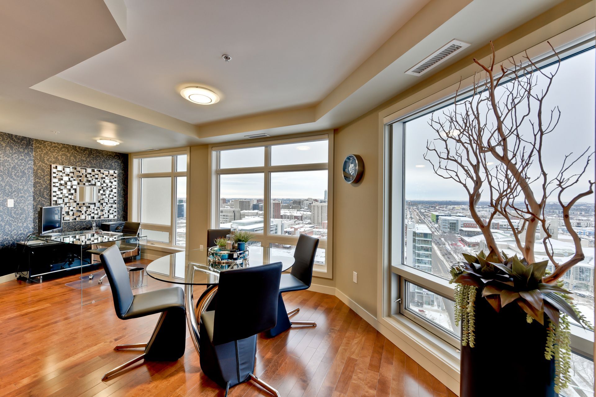A living room with a dining table and chairs and a large window
