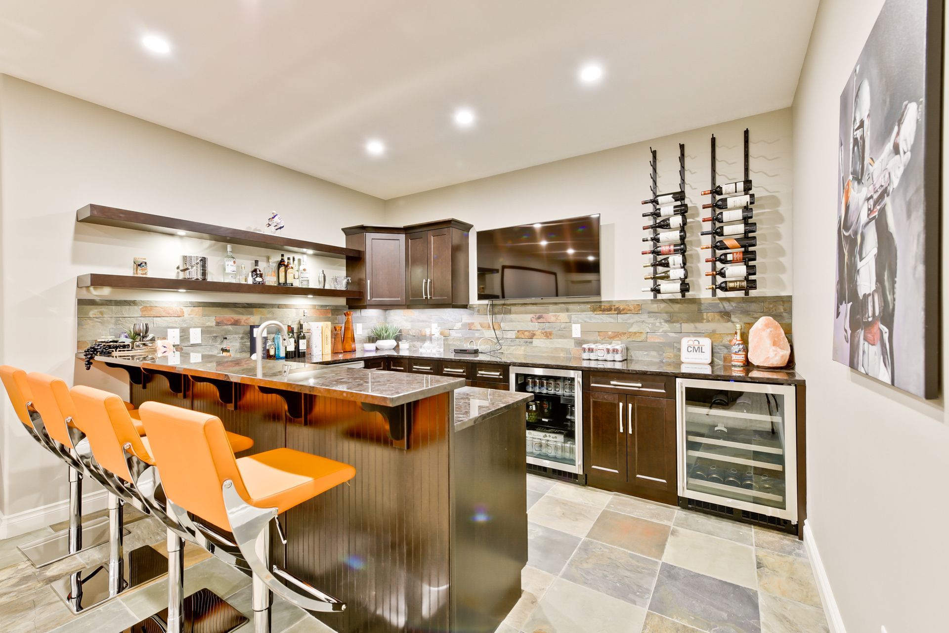 A kitchen with a bar and stools and a painting on the wall.