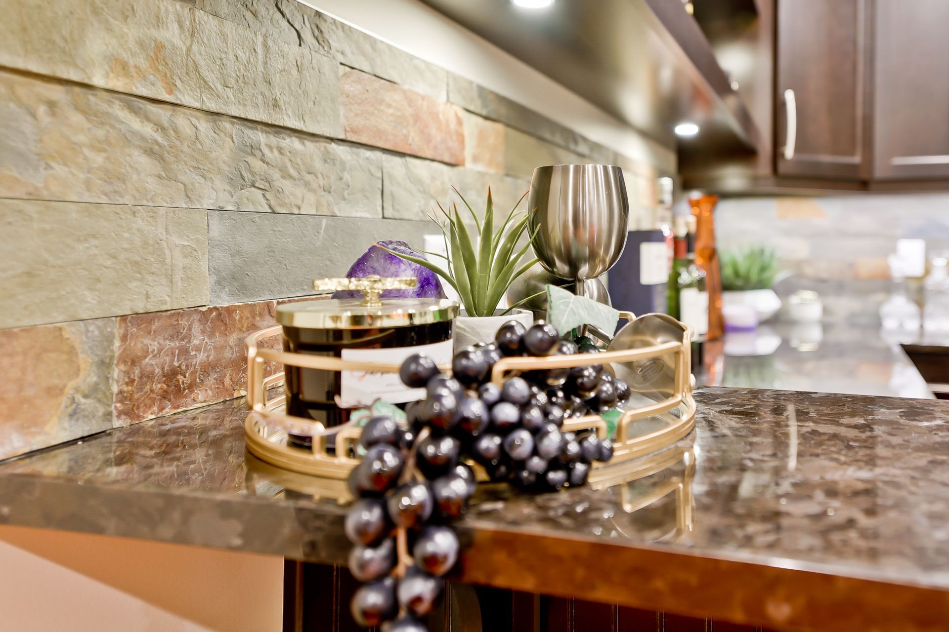 A bunch of grapes are on a tray on a counter in a kitchen.