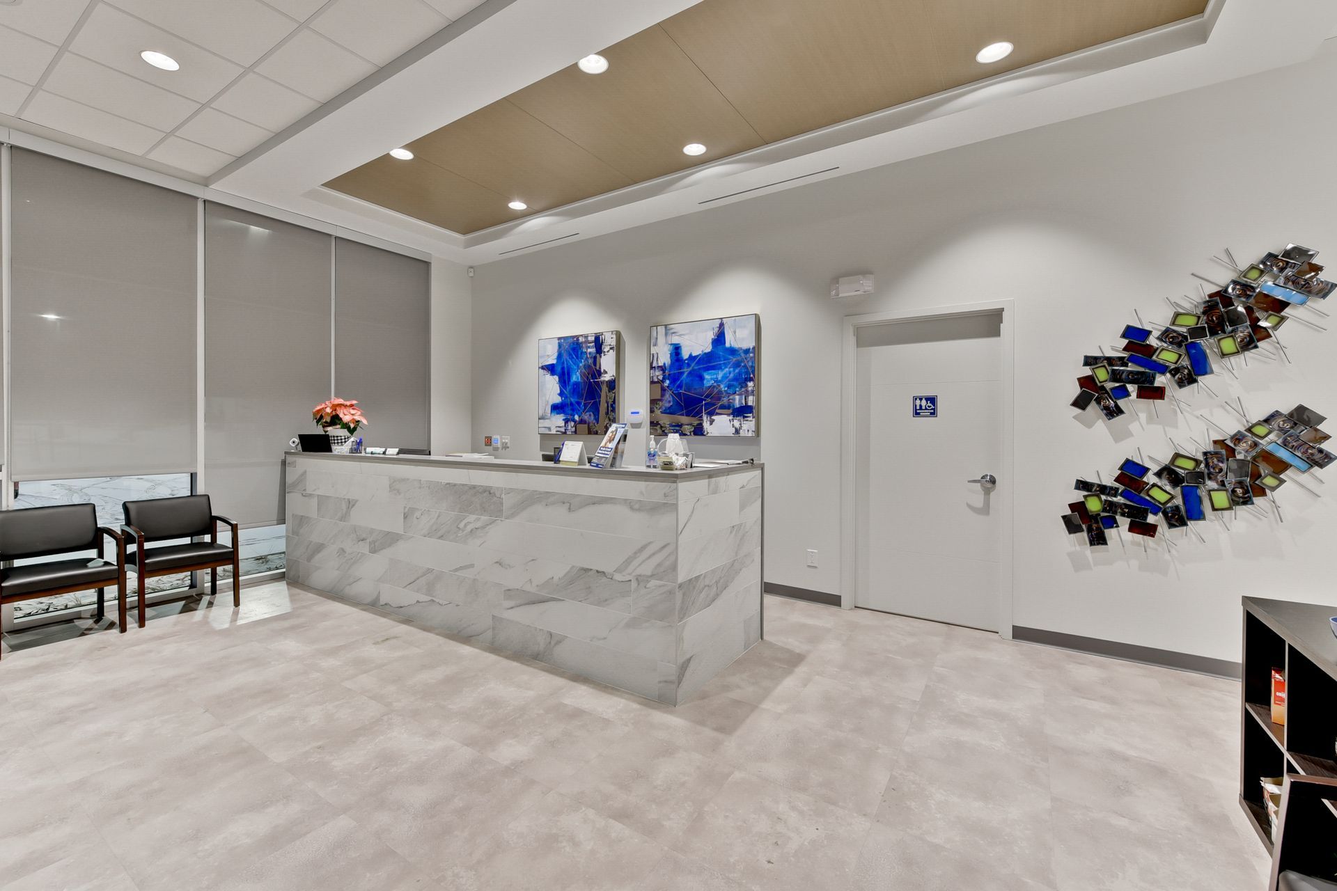 A waiting room with a marble counter and chairs.