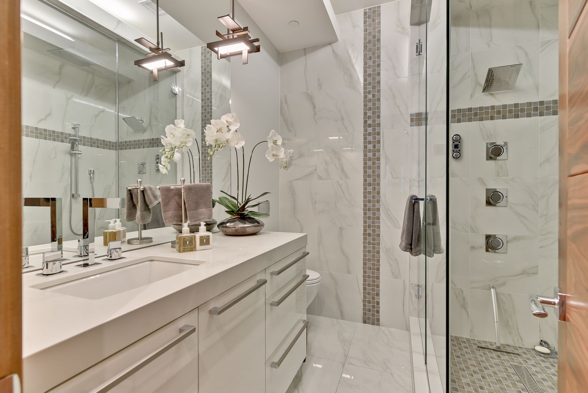 A bathroom with two sinks and a walk in shower.