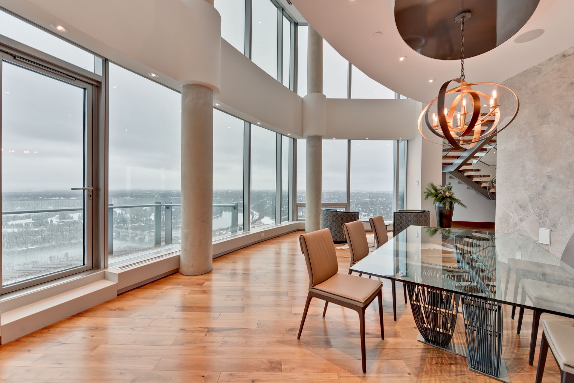 A large dining room with a glass table and chairs