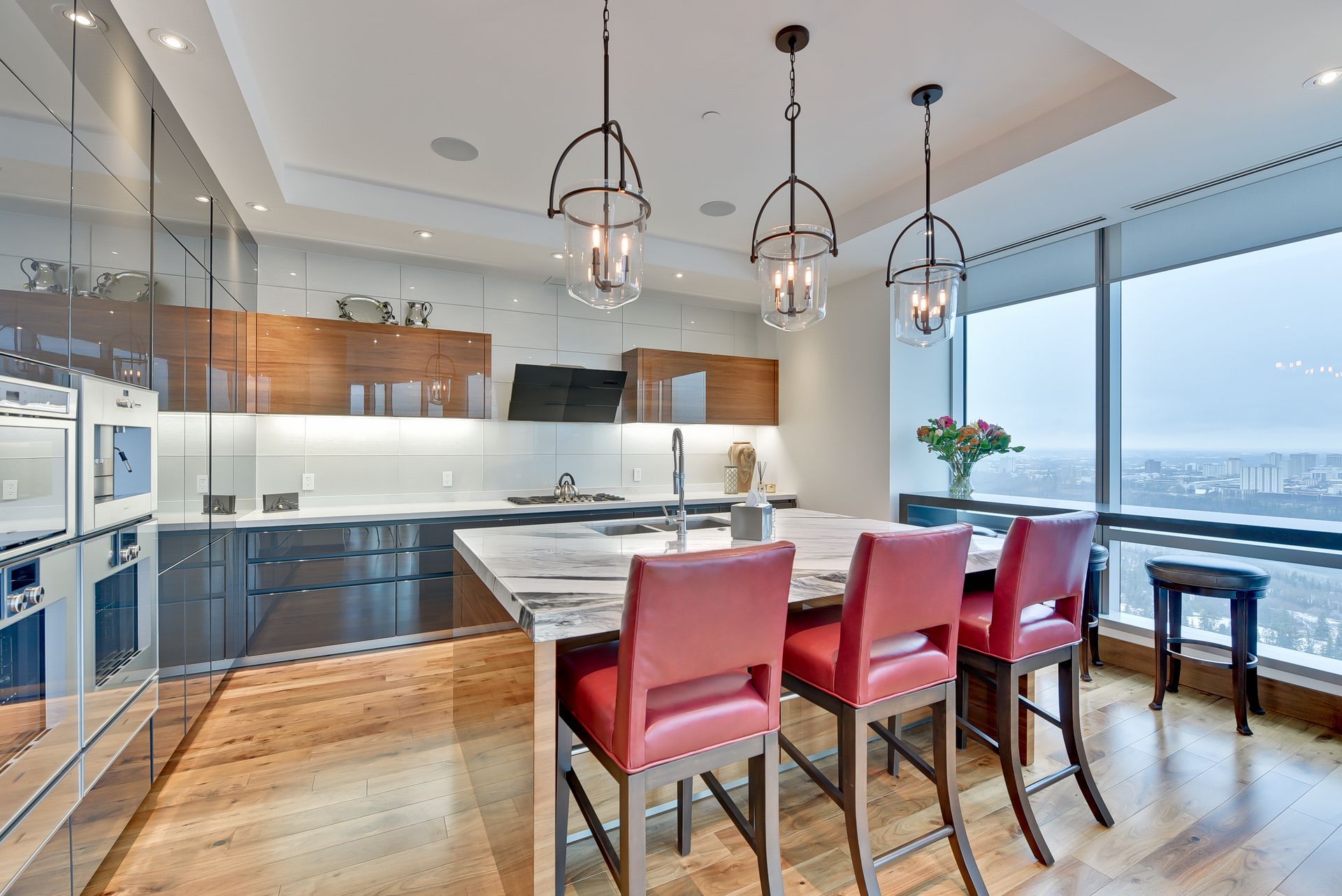 A kitchen with a large island and red chairs
