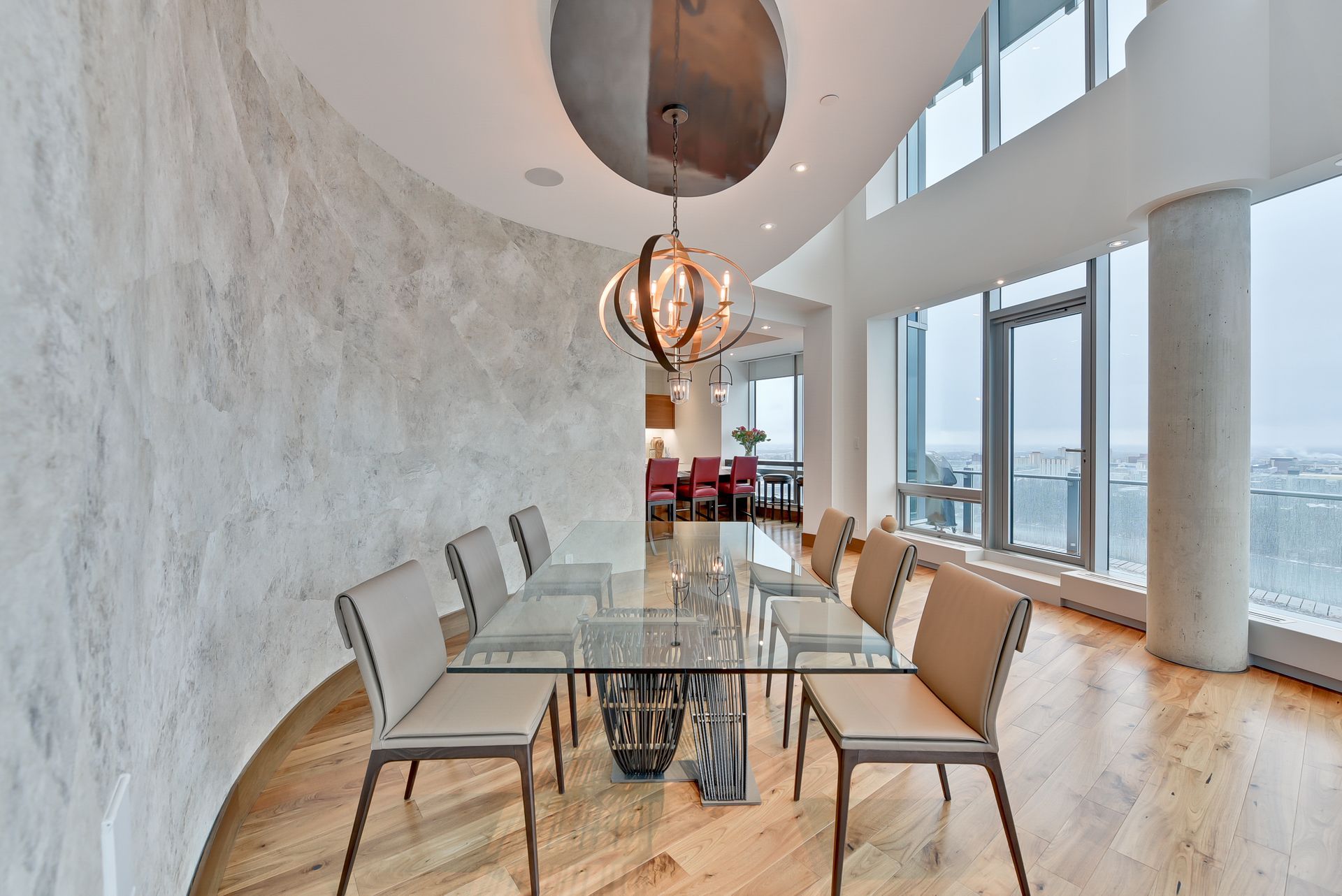 A dining room with a glass table and chairs and a chandelier hanging from the ceiling.