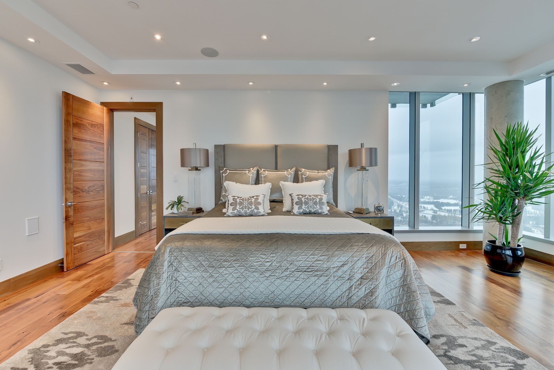 A bedroom with a large bed and lots of windows.