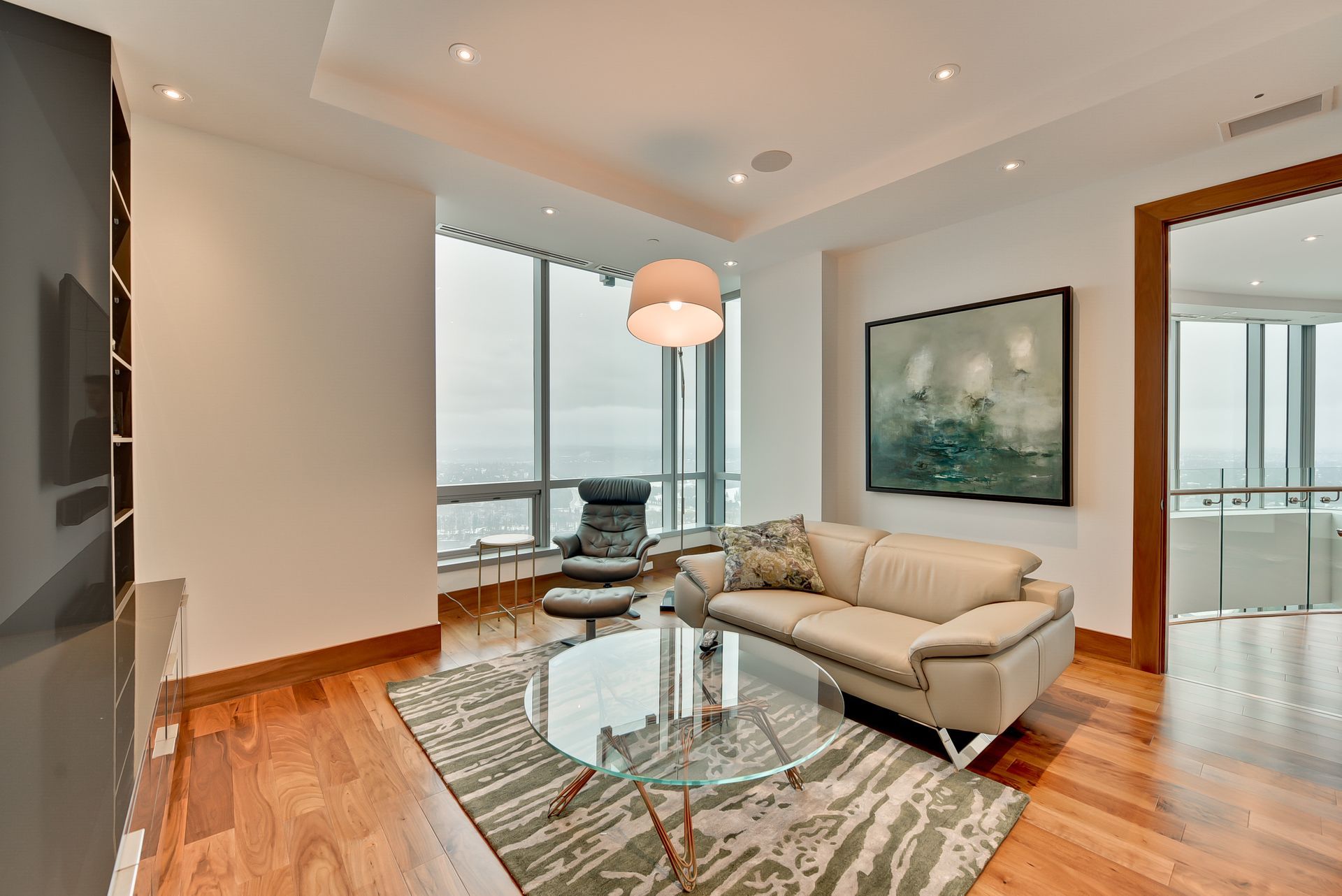 A living room with a couch , chair , table and a painting on the wall.