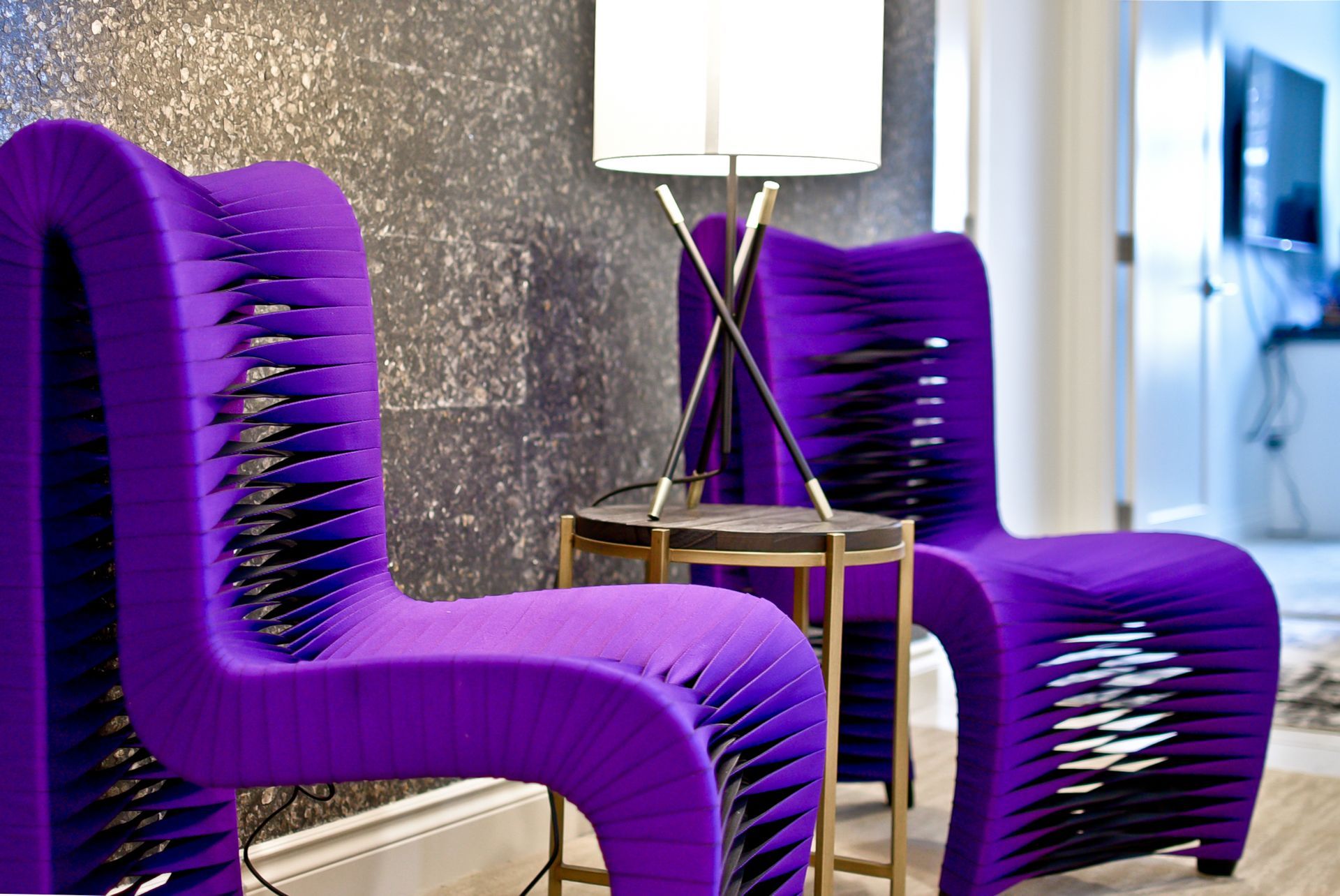 Two purple chairs are sitting next to each other in a room.