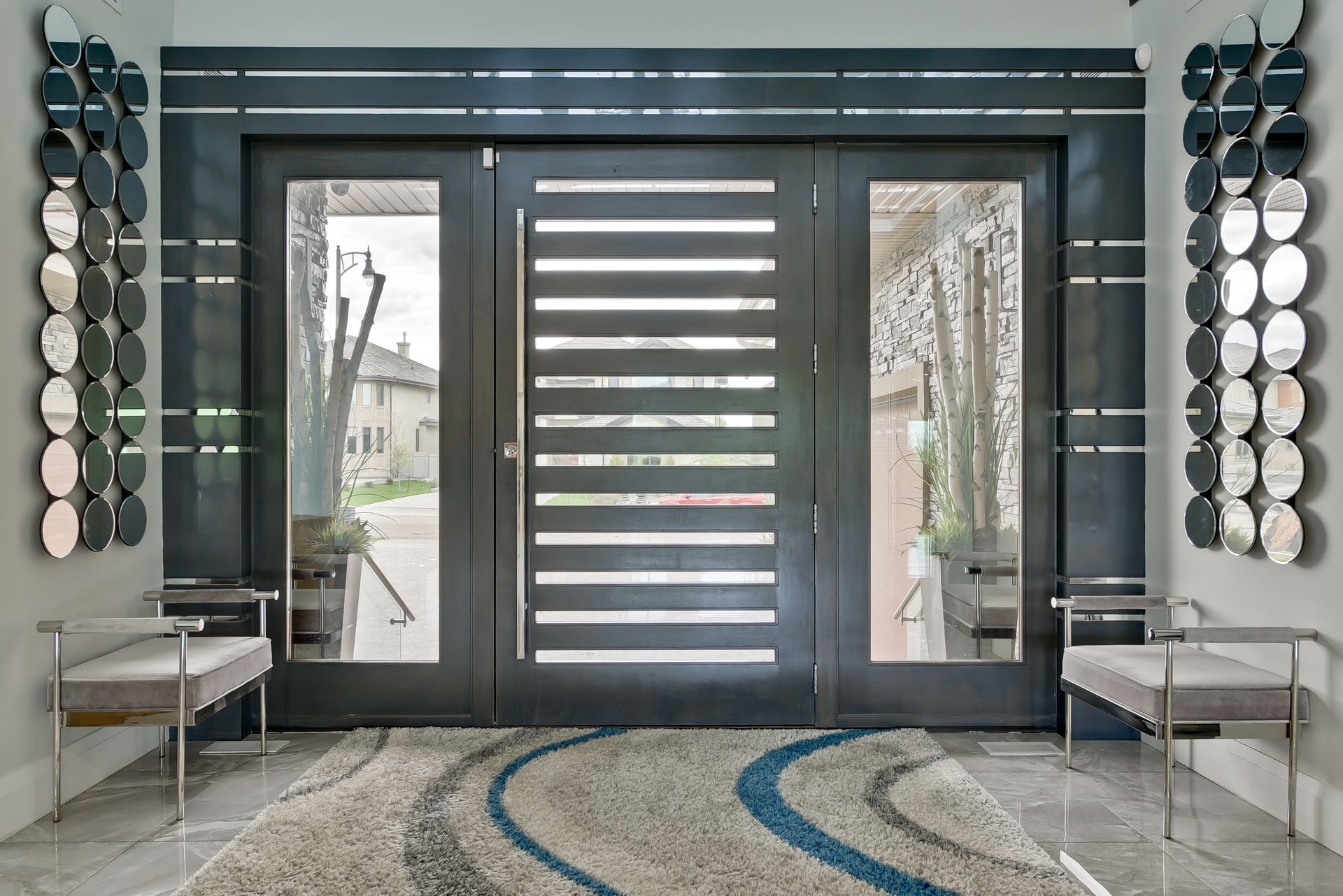 A hallway with a large door and a rug on the floor
