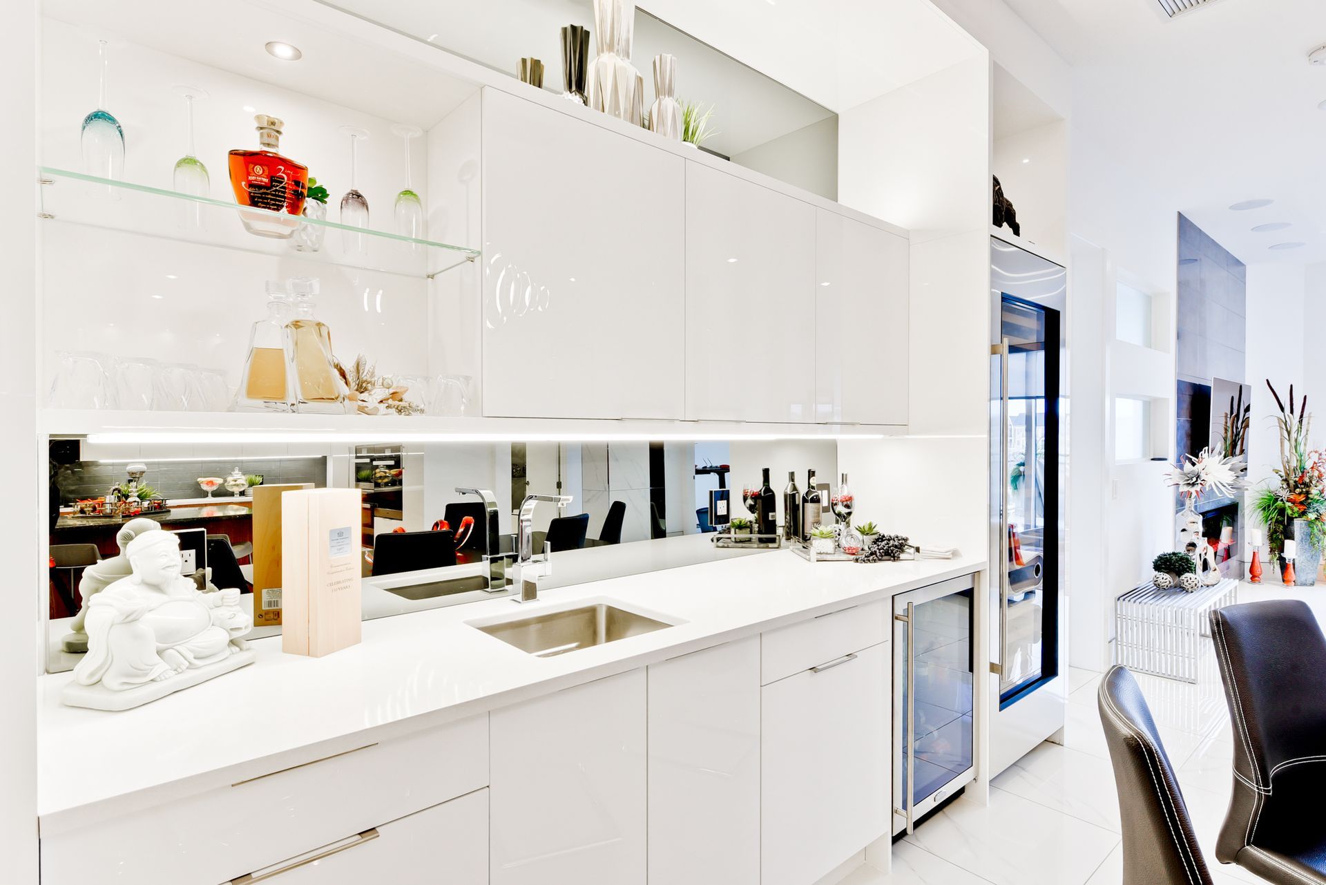 A kitchen with white cabinets and a stainless steel sink