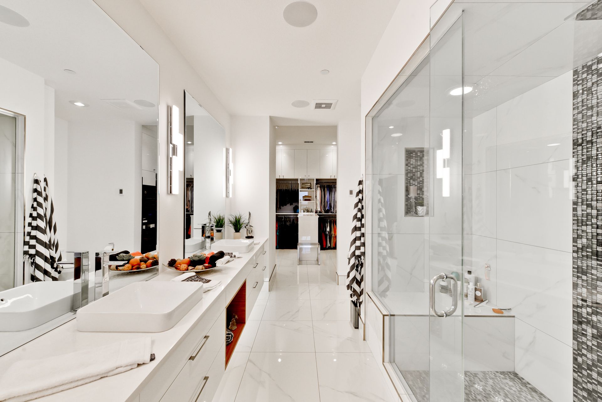 A bathroom with two sinks and a walk in shower.