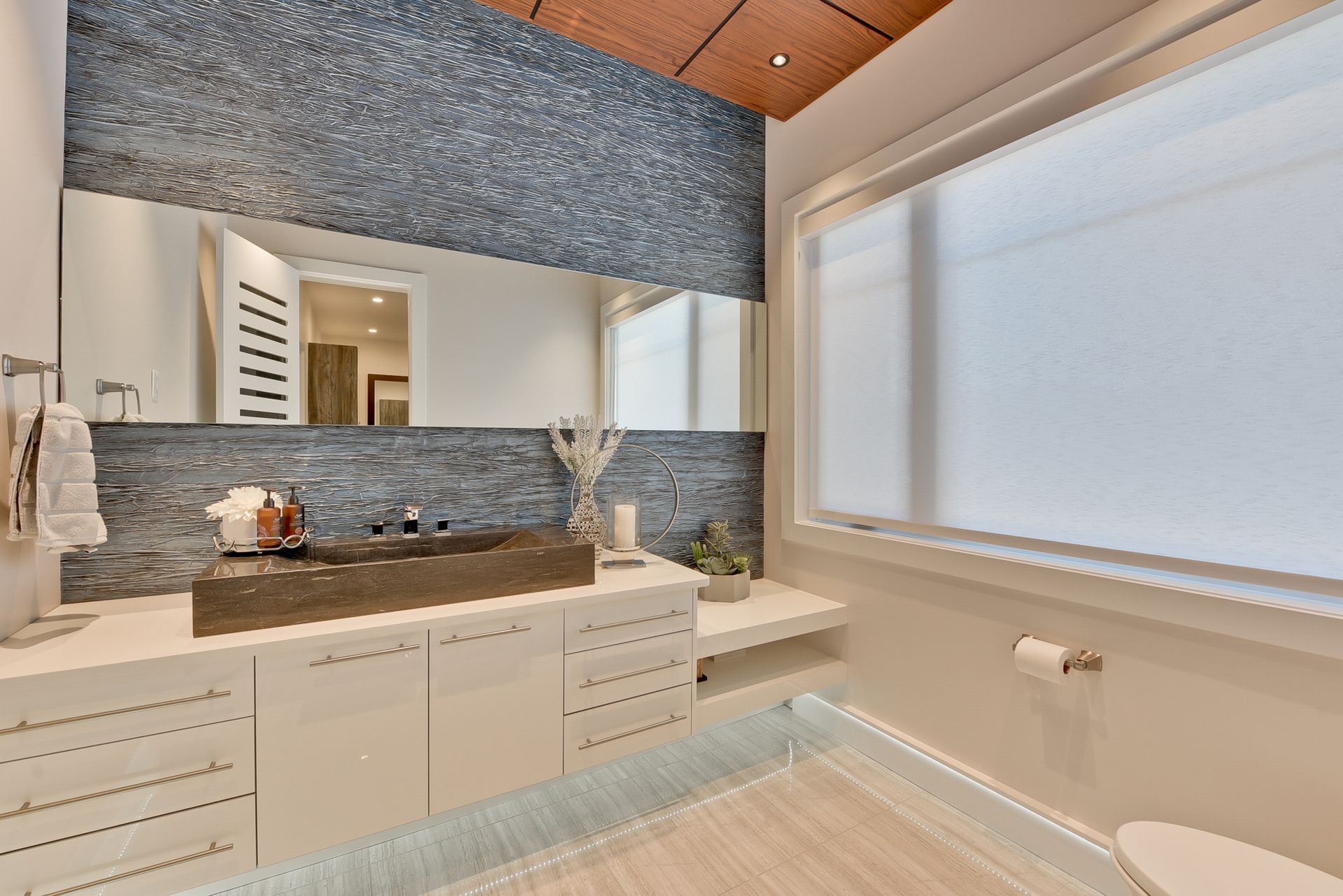 A bathroom with a sink , toilet , mirror and window