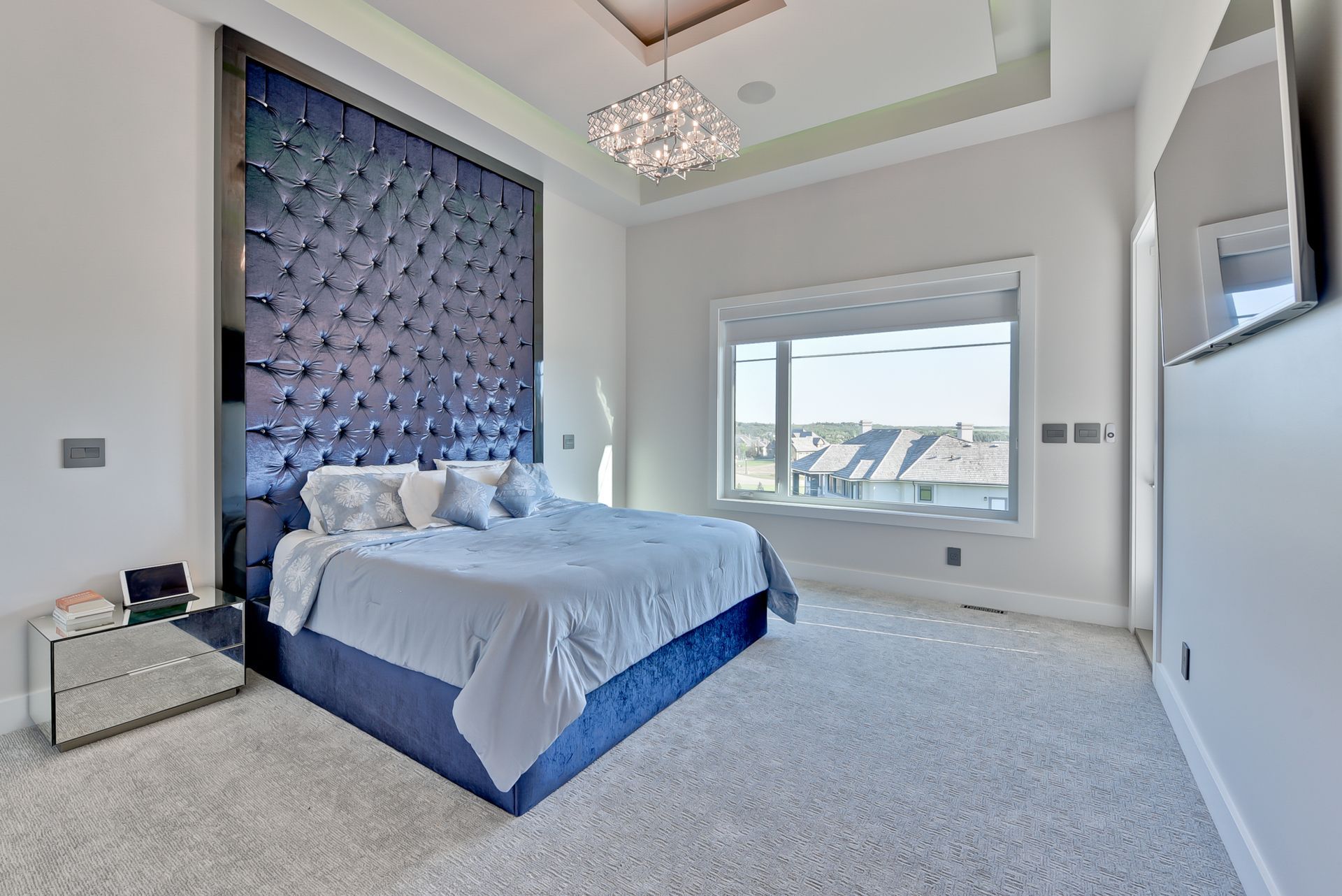 A bedroom with a large bed and a large window.