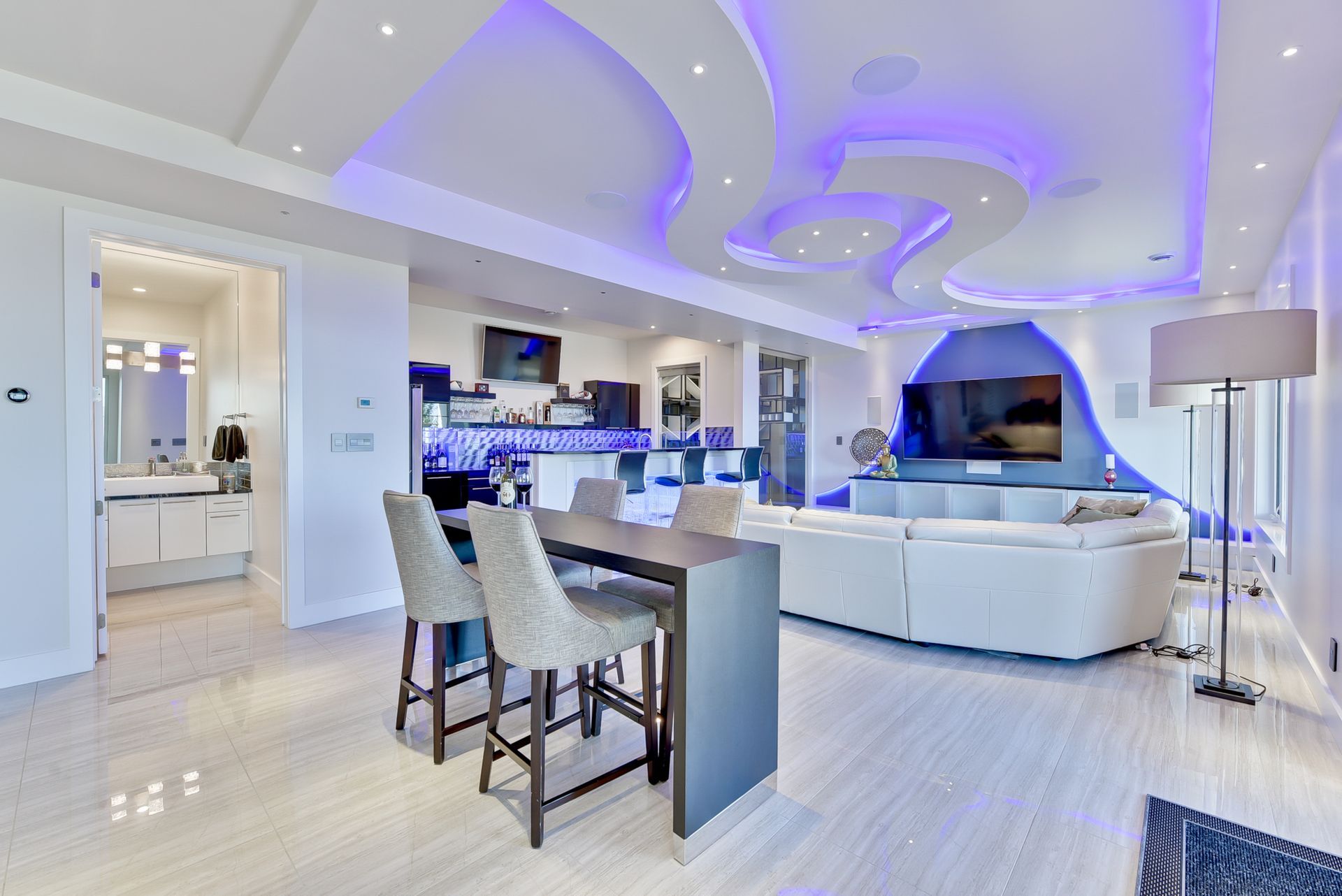 A living room with a couch , table , chairs and a television.