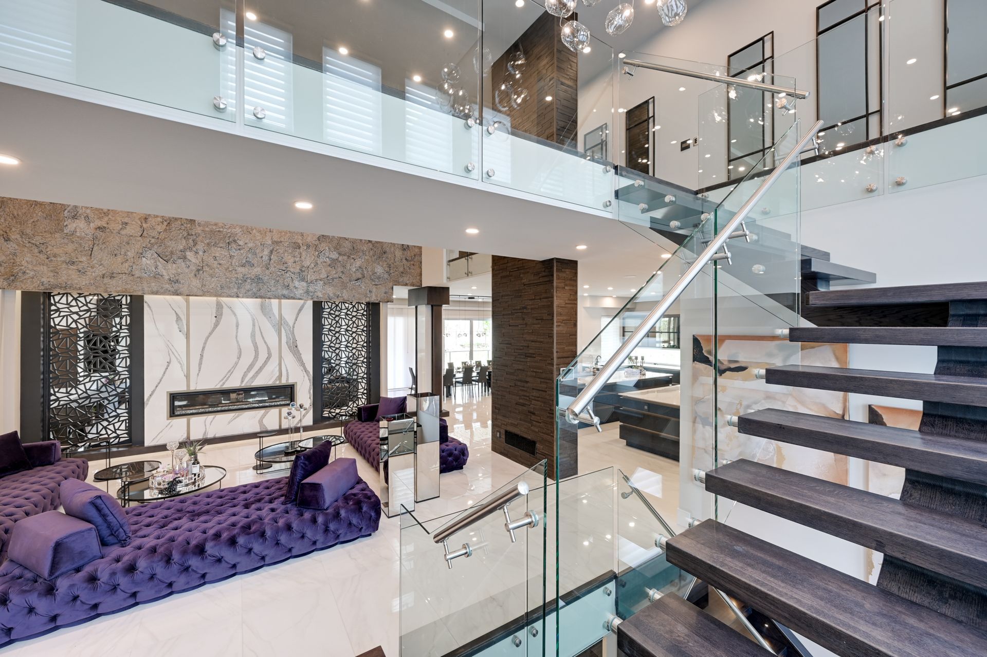 A living room with a purple couch and stairs leading up to the second floor.