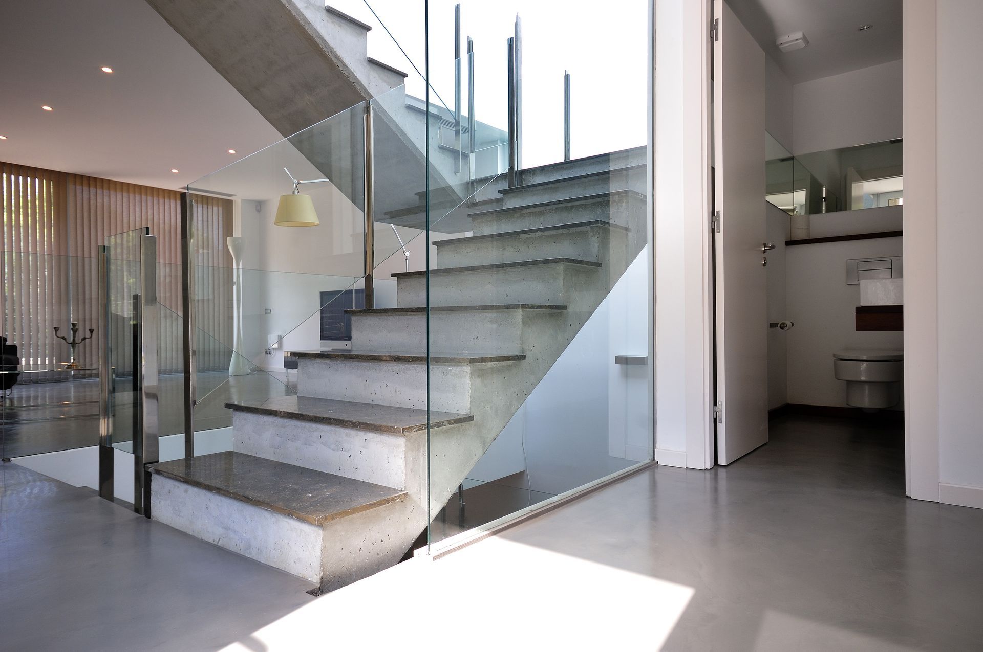 A modern staircase with a glass railing in a house