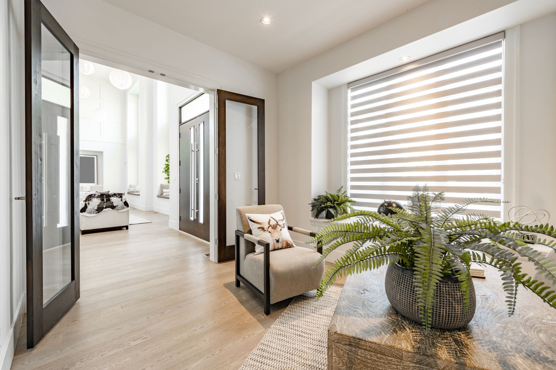 A living room with a chair and a plant on a table.