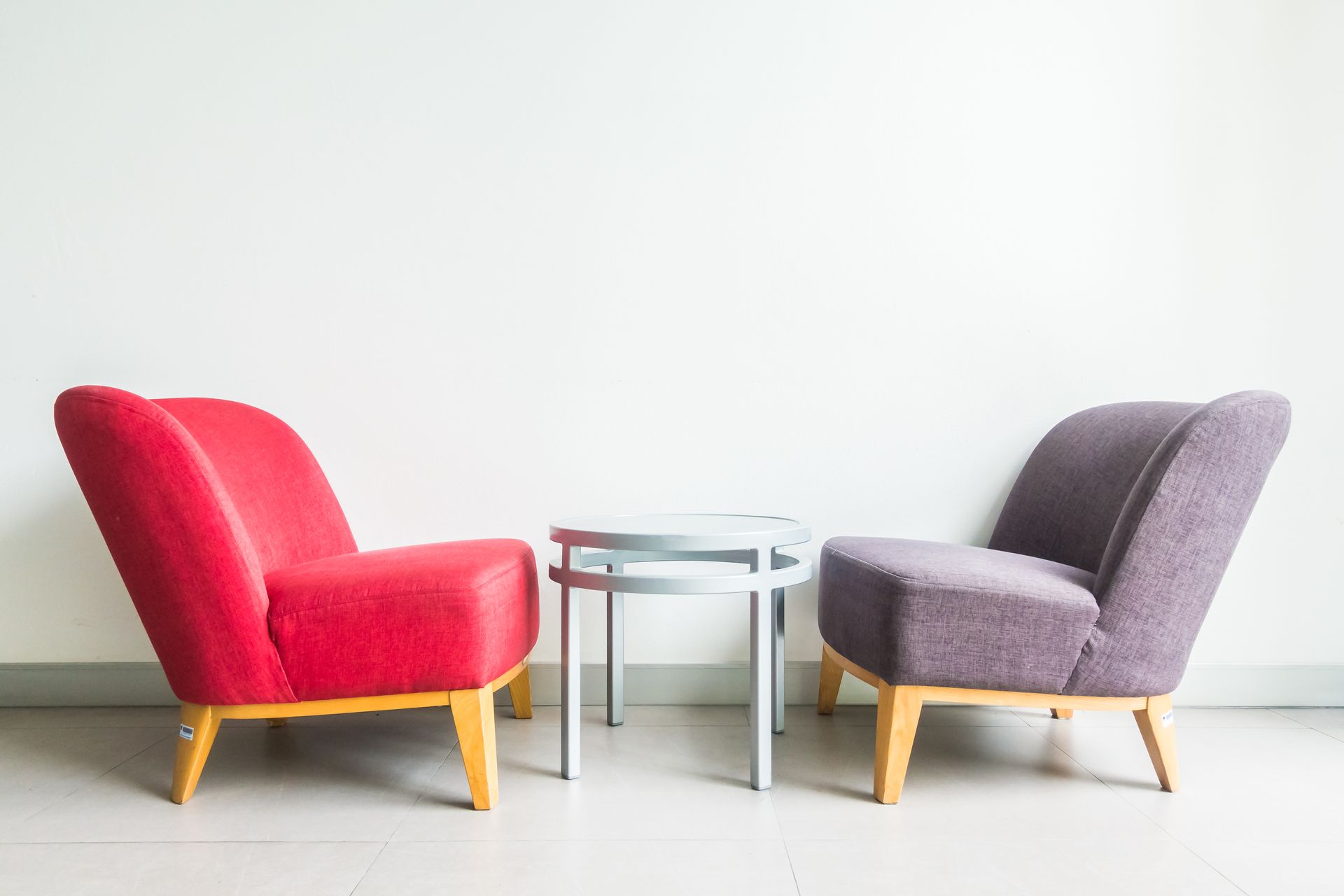 Two chairs and a table in a room with a white wall.
