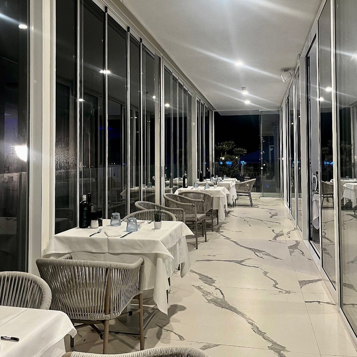 Un lungo corridoio con tavoli e sedie in un ristorante