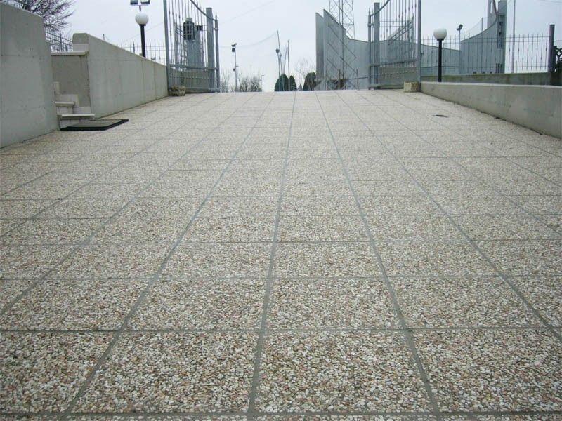 Un sentiero piastrellato con una recinzione sullo sfondo