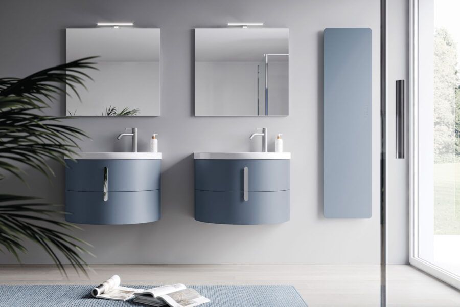 Un bagno con due lavandini, due specchi e una pianta.