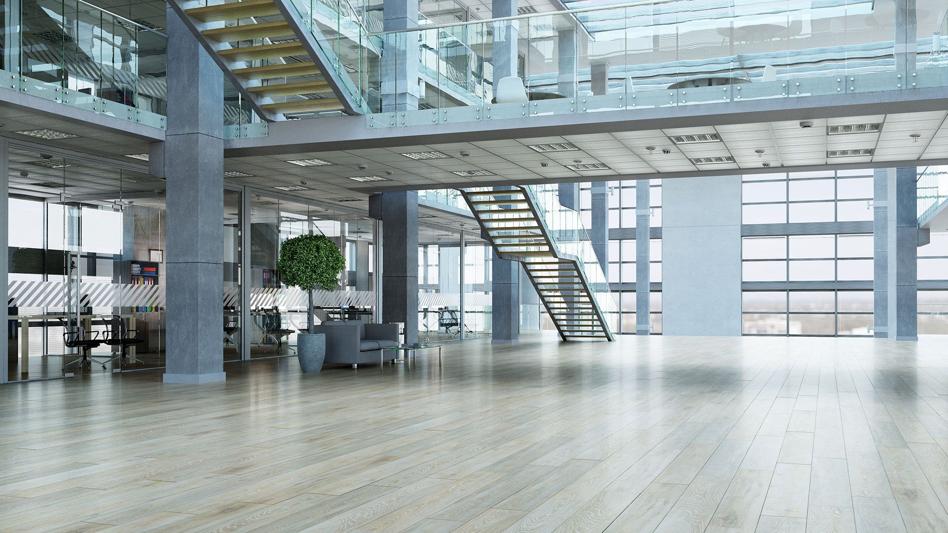 Un grande edificio per uffici vuoto con una scala e molte finestre.