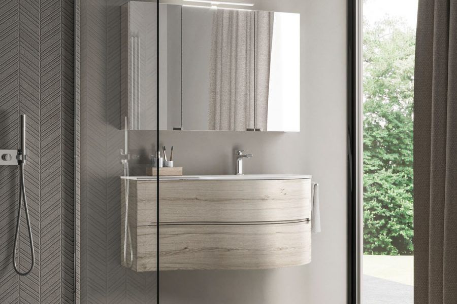 Un bagno con lavandino, specchio e doccia.