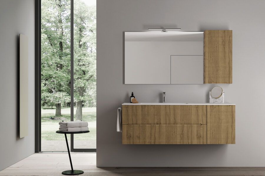 Un bagno con lavandino, specchio, armadietti e un tavolo.