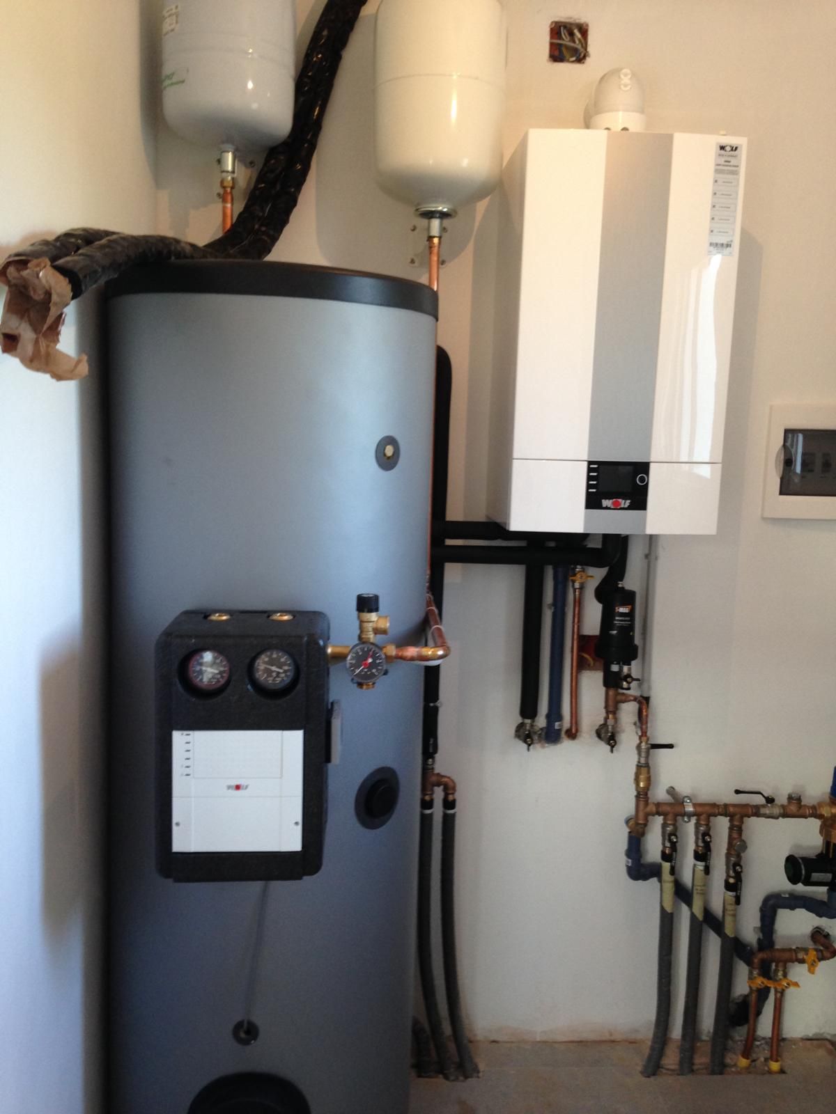 Mani che lavorano su una caldaia montata su una parete.