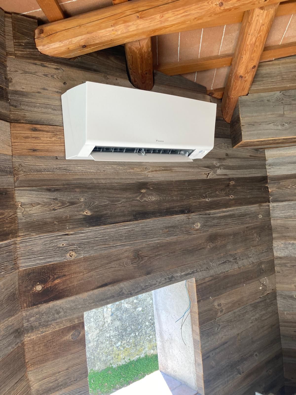 Una persona utilizza i misuratori per effettuare la manutenzione di un'unità di aria condizionata all'esterno di un edificio.