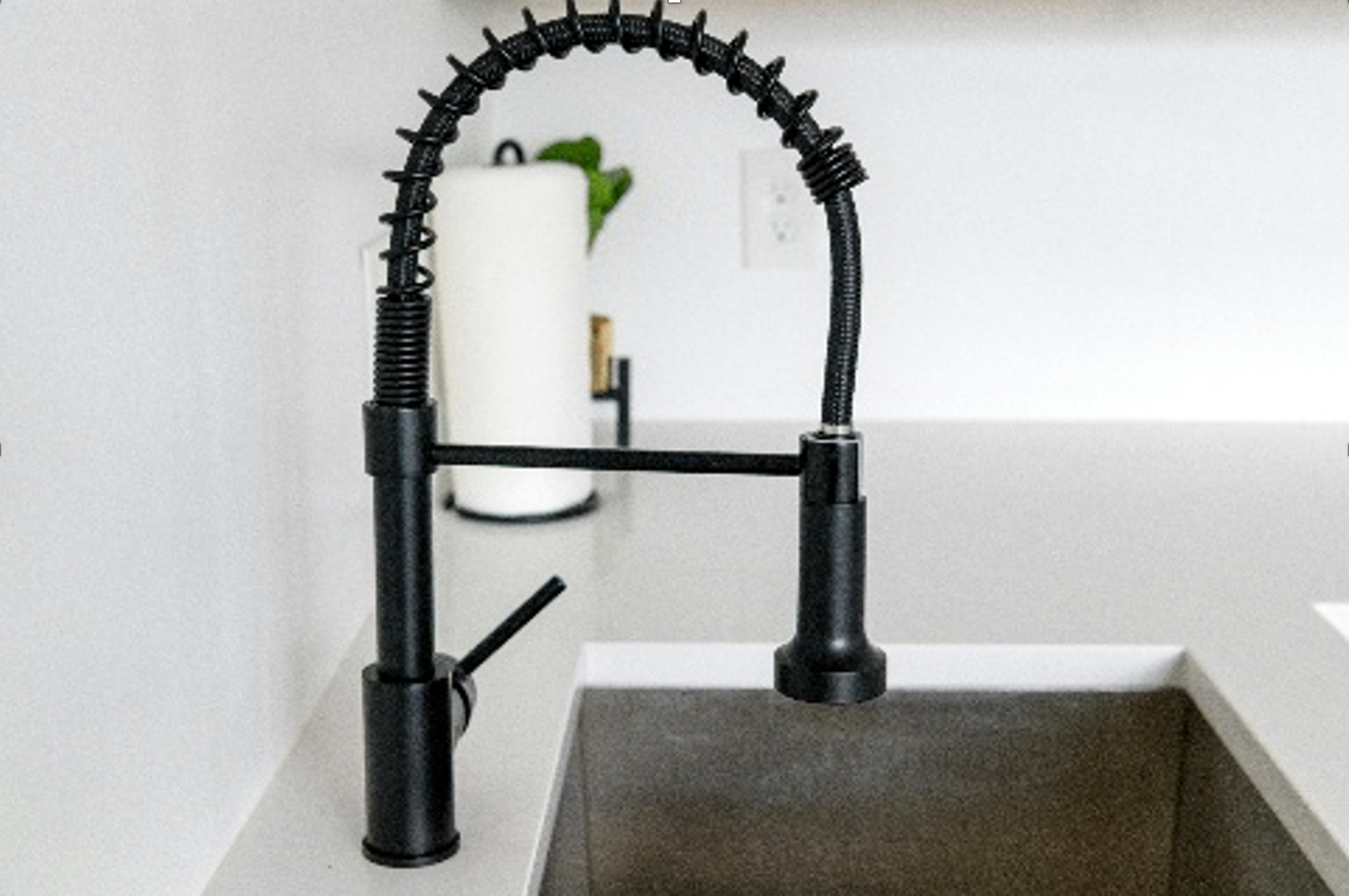 Black kitchen faucet over a gray sink, with a paper towel holder in the background. — Ausplumb NT in Winnellie, NT