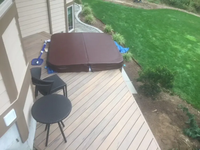 A hot tub is sitting on top of a wooden deck.