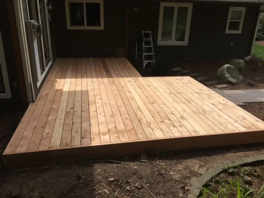A wooden deck is being built in front of a house