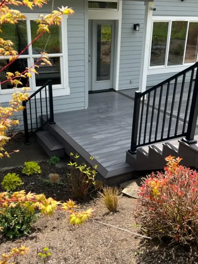 A porch with stairs and a railing in front of a house.