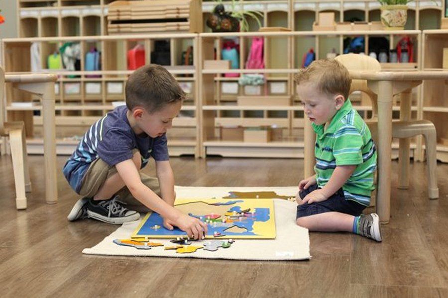 Children working with a Montessori world map puzzle