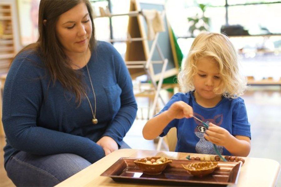 Guide observing child's work with Montessori materials