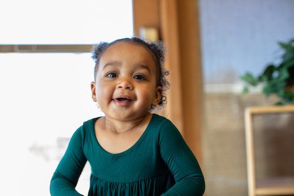 Toddler smiling in a Montessori classroom