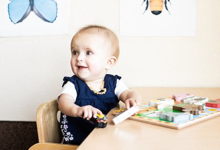 Infant working on a puzzle in a Montessori classroom