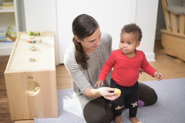 Guide and infant in a Montessori classroom