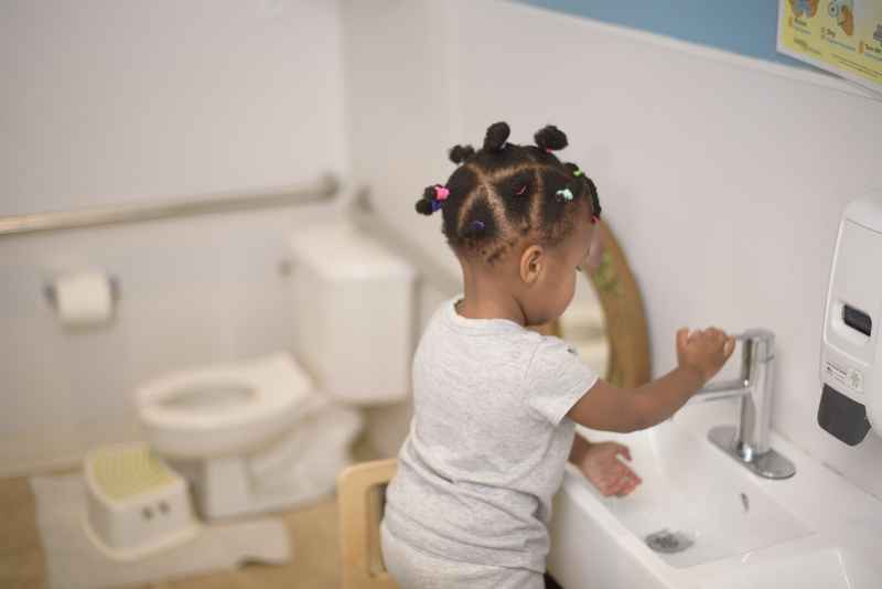 Montessori toddler washing their hands