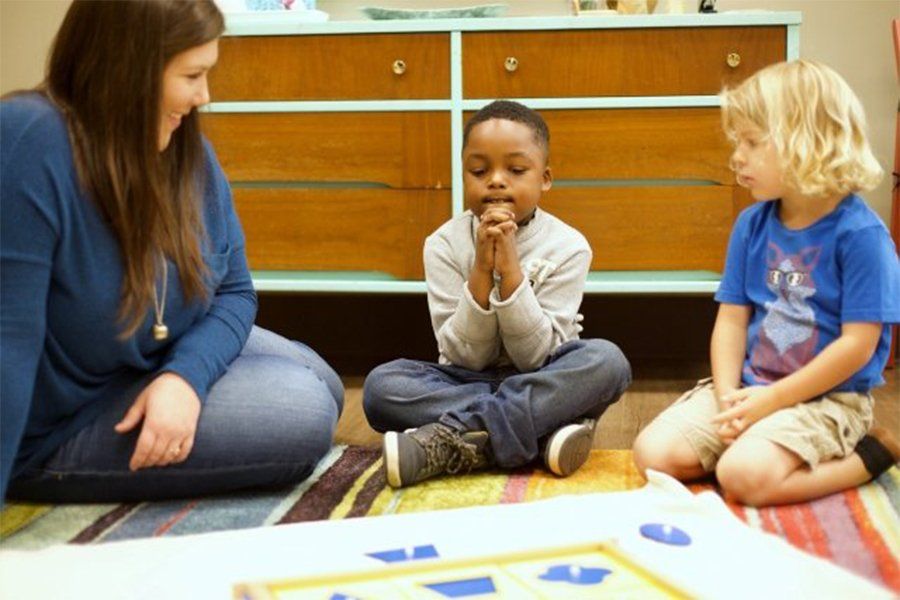 Guide and children in a Montessori classroom