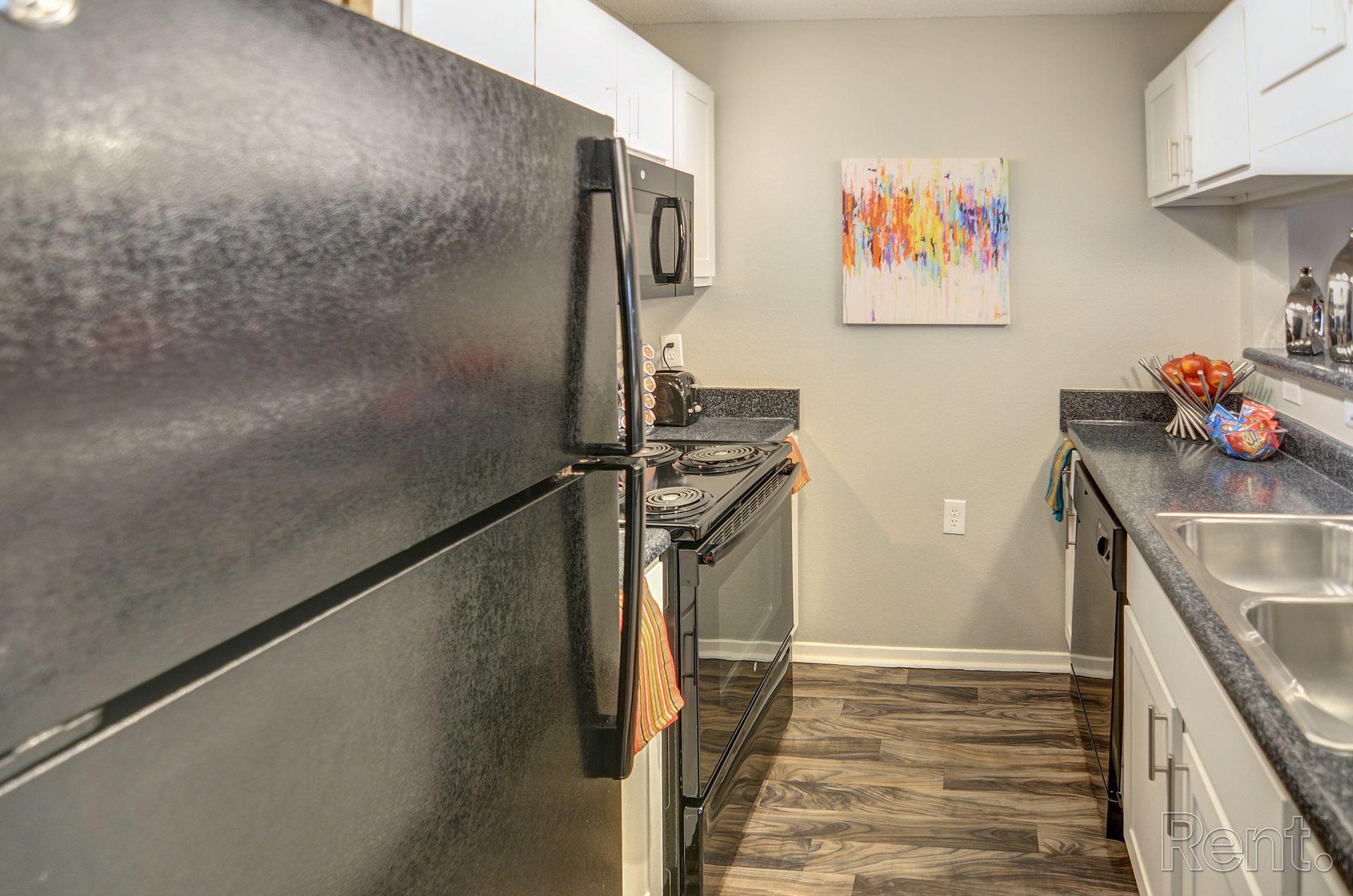 A kitchen with a refrigerator , stove , sink , and microwave.